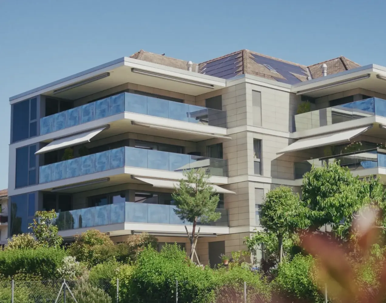 Façade du Centre 38 à Saint-Sulpice — résidence PPE contemporaine avec balcons vitrés et panneaux solaires, réalisée par Norwood